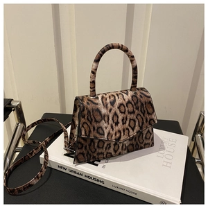 Detail of leopard print handbag with magnetic closure and textured faux leather finish