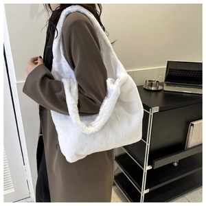 Vue latérale d'un sac cabas blanc en fausse fourrure avec une large bandoulière sur un mannequin
