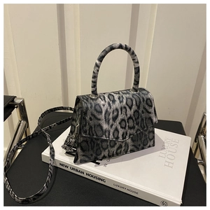 Detail of grey leopard print handbag with sturdy handle and magnetic flap closure