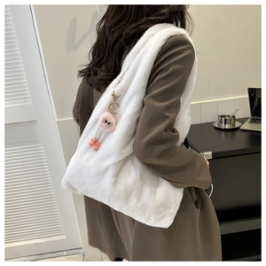 Sac à épaule en peluche blanche avec pendentif monstre rose vu de perspective