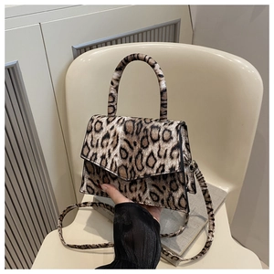 Detail view of leopard print crossbody bag with magnetic flap and top handle
