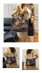 Three-way view of leopard print canvas tote bag with purple straps and bear charm