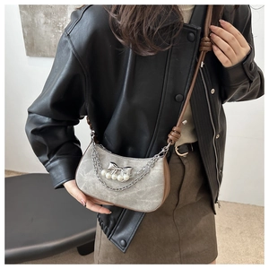 Détail du sac bandoulière gris avec nœud argenté, perles et doubles bandoulières en chaîne
