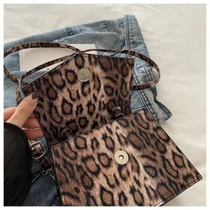 Detail view of the leopard print handbag showing the dual silver magnetic snap closures