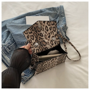 Detail view of leopard print crossbody bag with magnetic closure and interior space