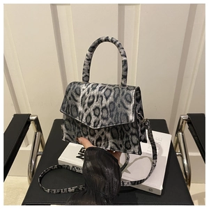 Detail view of the gray leopard print crossbody bag with magnetic flap and slim handle
