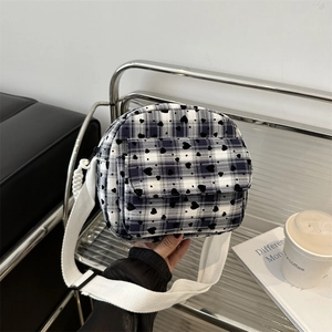 Minimalist checkered crossbody bag with black heart prints and wide white shoulder strap