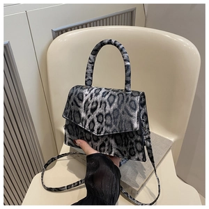 Detailed view of the leopard print faux leather handbag with a magnetic flap closure