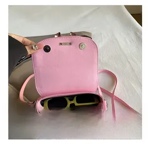 Pink small crossbody bag interior view showing capacity for sunglasses and lipstick