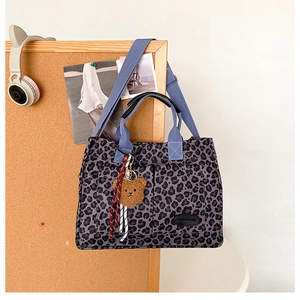 Detail view of purple leopard canvas tote bag with dual front pockets and bear charm