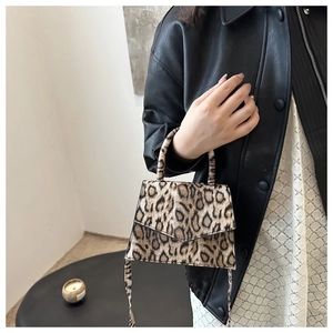 Close-up of leopard print mini handbag with textured leather and adjustable shoulder strap