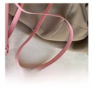 Detail shot of pink PU leather shoulder strap with reinforced stitching on a small bag
