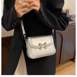 Détail macro du mini sac argenté avec nœud métallique et finition texture premium