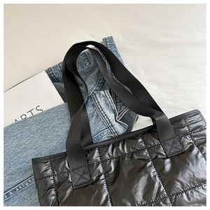 Top view of black quilted puffer tote bag made of shiny water-resistant nylon fabric