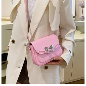 Detail of pink leather crossbody bag with silver mirror bow and adjustable shoulder strap