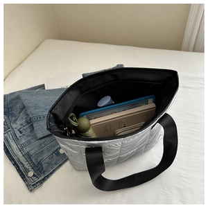 Interior view of large silver quilted tote showing storage for tablet, umbrella and wallet