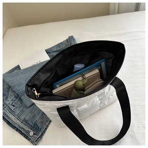 Internal view of a spacious white quilted tote bag filled with daily essentials