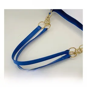 Close-up of royal blue tote bag featuring golden metal ring and chain link connectors
