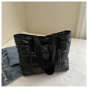 Detailed view of the black quilted puffer tote bag with durable nylon texture and handle