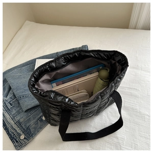 Spacious black quilted tote bag showing interior storage capacity for daily essentials