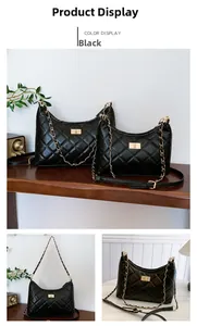 Detail of black quilted shoulder bag featuring a gold twist lock and chain strap