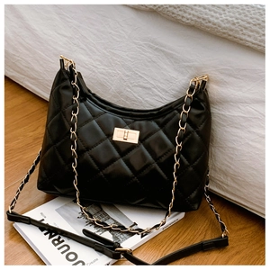 Detail of classic black quilted shoulder bag with gold chain strap and twist lock