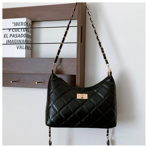 Detail shot of black quilted shoulder bag with gold twist-lock and chain strap