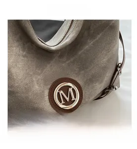 Gros plan sur le denim délavé gris-brun avec patch en cuir et boucle en métal brossé