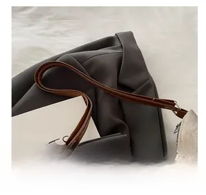 Détail du sac cabas en velours beige avec bandoulière en cuir marron et boucle métallique
