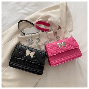 Detail of quilted flap bag with butterfly metal clasp and embossed fashion logo
