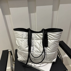 Large silver quilted tote bag with black straps and spacious interior for daily commute