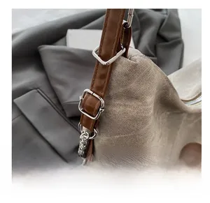 Détail de la bandoulière réglable en cuir avec boucle argentée sur sac fourre-tout