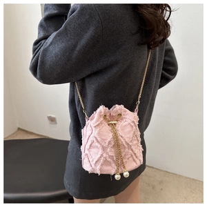 Vue détaillée du sac seau matelassé rose avec cordon en perles et bandoulière chaîne dorée