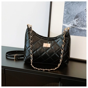 Detailed view of black quilted leather tote with gold twist lock and chain strap