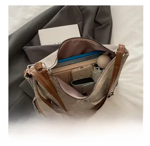 Détail montrant la grande capacité du sac avec parapluie, livre et téléphone à l'intérieur