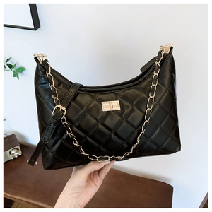 Close-up of black quilted tote bag with gold chain strap and metallic twist lock