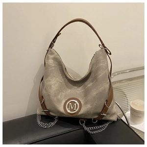 Detail of taupe canvas hobo bag with M-logo, leather handle and silver metal chain strap