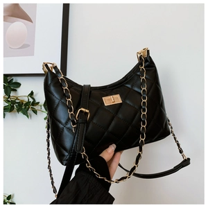 Detailed view of black quilted leather shoulder bag featuring a gold rotating square lock