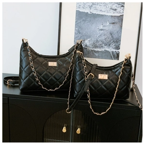 Detail of black quilted leather tote bags featuring gold chain straps and twist locks