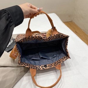 Leopard print canvas tote bag with brown straps and spacious interior pockets