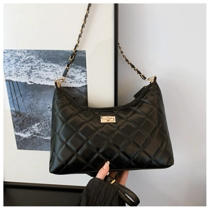 Detail of classic black quilted tote bag featuring a gold twist-lock and chain strap