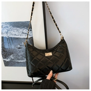 Black quilted hobo bag with gold twist lock and chain strap on a minimalist background