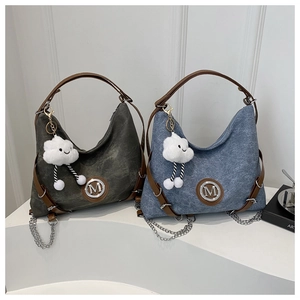 Detail of dark green and blue tote bags with leather handles and cloud charm