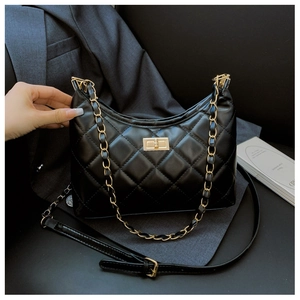 Close-up of black quilted hobo bag with gold chain strap and turn-lock closure detail