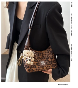Détail du sac hobo léopard avec bandoulière en cuir et charm de chat en peluche