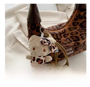 Détail d'un charm ours en peluche sur un sac à bandoulière tendance avec motif léopard