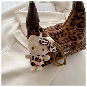 Détail du sac croissant léopard avec bandoulière cuir et breloque chat peluche