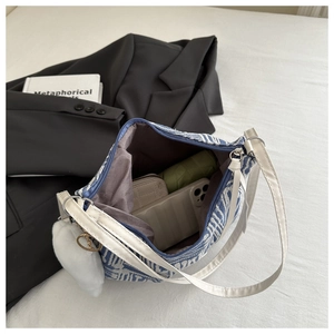 Detail view of spacious blue jacquard bucket bag showing large interior for essentials