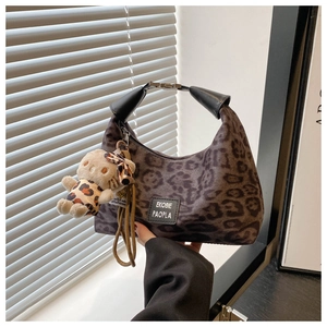 Détail du sac croissant à imprimé léopard avec fermoir en métal et pendentif peluche