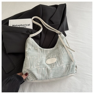 Macro view of light green jacquard fabric bucket bag with white leather strap detail